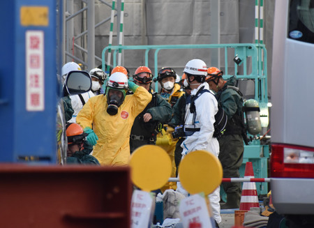 陥没事故が起きた下水道管内に立ち入るため、酸素ボンベやマスクを装着する警察官や消防隊員ら=1日午前、埼玉県八潮市