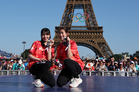 パリ五輪で銅メダルを獲得し、ファンの前で記念撮影をするバドミントン女子の志田千陽(左)と松山奈未=2024年8月、パリ(AFP時事)