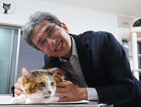 九州大の佐々木裕之特別主幹教授と三毛猫。三毛猫のオレンジか黒の毛色を切り替える遺伝子を発見した(同氏提供)