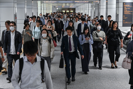 東京の新宿駅近くを歩く通勤客ら(AFP時事)