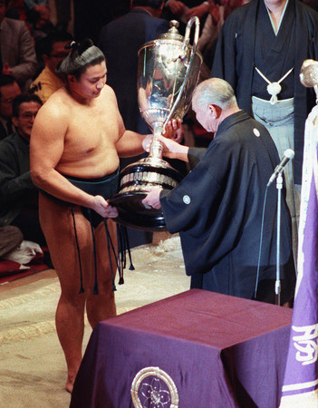 1992年初場所、史上最年少で初優勝を遂げた貴花田(後の横綱貴乃花)。伯父で二子山理事長(当時、元横綱初代若乃花)の花田勝治氏から賜杯を授けられる=1992年1月、東京・両国国技館