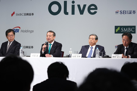 個人向け資産運用サービスに関する共同記者会見で質問に答える三井住友フィナンシャルグループの中島達社長(中央左)。同右はSBIホールディングスの北尾吉孝会長兼社長=16日、東京都港区