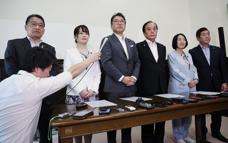 参院へ財政金融委員長の解任決議案を提出し、取材に応じる野党議員=21日午後、国会内