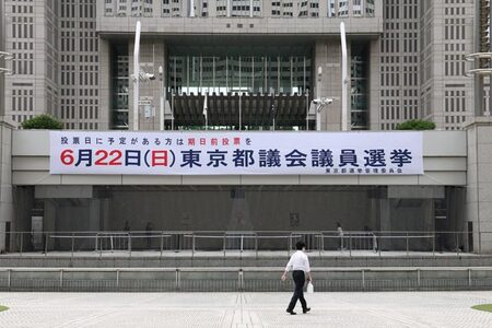 東京都庁第一本庁舎前に掲示された都議選の横断幕=13日、東京都新宿区