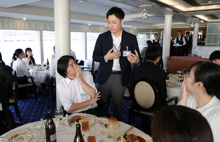 クルーズ船で行われた家電量販大手ノジマの内々定式で、懇談する社員と学生=5日午後