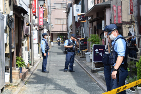 ガールズバー店長ら2人が男に刃物で刺され死亡した事件で、現場周辺を捜査する警察官ら=6日午前、浜松市中央区