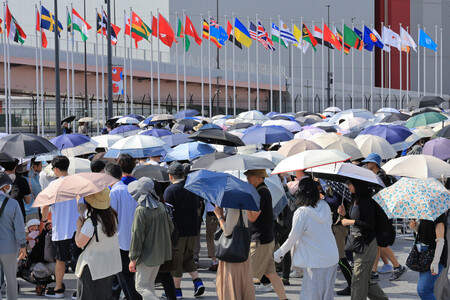 大阪・関西万博の会場に向かう人たちで混雑する東ゲート前＝１２日午前、大阪市此花区