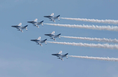 大阪・関西万博の会場上空を飛行する航空自衛隊の曲技飛行チーム「ブルーインパルス」=12日午後、大阪市此花区