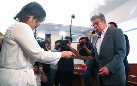 静岡県伊東市議会の中島弘道議長(右)に「卒業証書」の提出拒否の回答書を手渡す田久保真紀市長=18日午後、同市議会