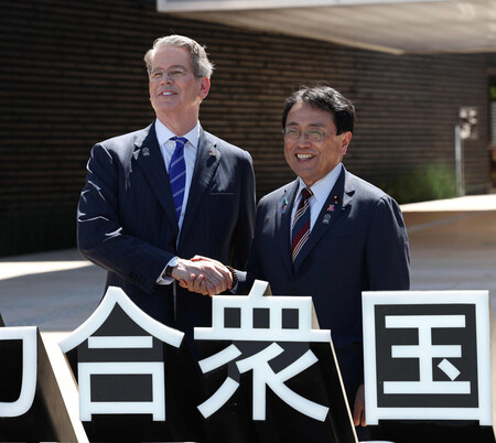 大阪・関西万博の米国館前で握手するベセント米財務長官(左)と赤沢亮正経済再生担当相=19日午後、大阪市此花区