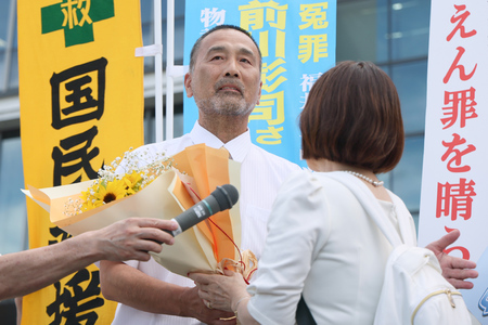 福井女子中学生殺害事件の再審判決で無罪が言い渡され、花束を受け取る前川彰司さん(左)=7月18日、金沢市
