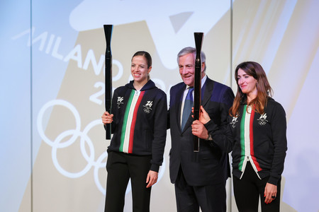 大阪・関西万博のイタリア館で初披露されたミラノ・コルティナ冬季五輪・パラリンピックの聖火リレートーチ。左から元フィギュアスケート選手のコストナーさん、タヤーニ副首相、パラ陸上選手のカイロニさん=14日午後、大阪市此花区