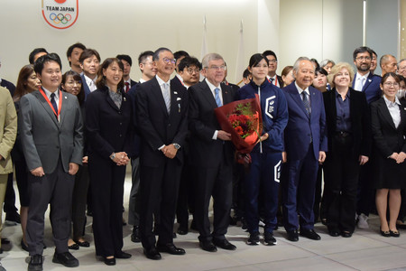 花束を手に、日本オリンピック委員会職員らとの写真撮影に臨む国際オリンピック委員会のバッハ会長(前列中央)=9日午後、東京都新宿区