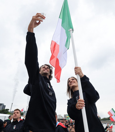 パリ五輪開会式の船上パレード中に記念撮影するイタリア選手団の旗手、ジャンマルコ・タンベリ（左）ら＝２６日、パリ（ロイター時事）