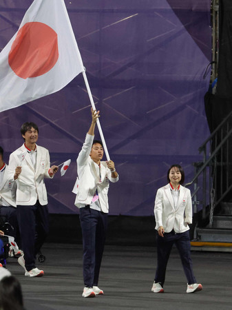 開会式で入場する日本選手団の旗手を務める石山大輝（中央）と西田杏（右）＝２８日、パリ