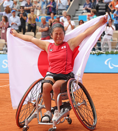 女子シングルスで金メダルを獲得し、日の丸を掲げる上地結衣＝６日、パリ