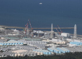 処理水の海洋放出が開始された東京電力福島第１原発。敷地内には処理水をためるタンクが立ち並ぶ＝２４日午後、福島県（時事通信チャーター機より）
