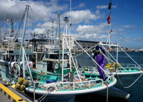 ２４日、東京電力福島第１原発に近い福島県浪江町の漁港で働く漁師（ＥＰＡ時事）