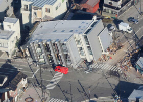 地震で倒壊したとみられるビル（中央）＝２日午前、石川県輪島市（時事通信チャーター機より）