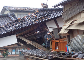 地震で倒壊した自宅で片付けをする寺尾直樹さん＝３日午後、石川県七尾市の能登島