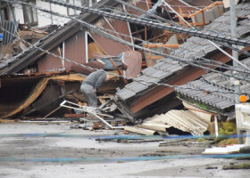 倒壊した家屋をのぞき込む住民＝３日、石川県珠洲市