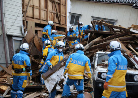 倒壊した建物に取り残された人がいないか捜索する警察官＝４日午前、石川県輪島市