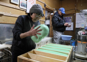 つきたての餅を木型に入れて、形を整える白山フサ子さん（左）＝７日、石川県志賀町