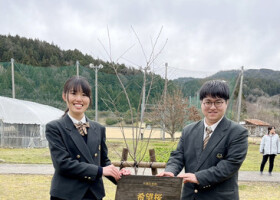 卒業式を前に、復興への希望を込めて桜の木を植えた石川県立門前高校３年の大岩紅葉さん（左）と田思陸さん＝２月２９日、石川県輪島市