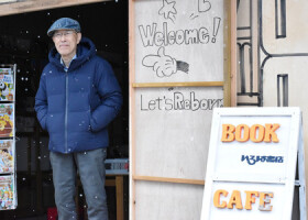 仮店舗で営業を再開した「いろは書店」と、店主の八木久さん＝２１日、石川県珠洲市
