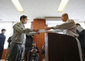 石川県輪島市の入庁式で、坂口茂市長（右）から辞令を受け取る新人職員＝１日午前、同市