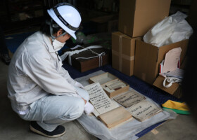 被災した建物から運び出した古文書を確認する関係者＝３月３０日、石川県能登町