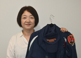 ボランティアセンター運営時に着用していた水防服を持つ中川奈穂子さん＝４日、熊本市