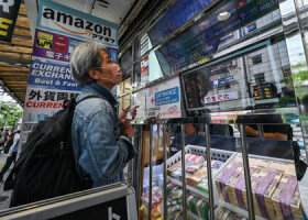東京都内の両替店で、レートの表示を確かめる男性＝４月２９日（ＡＦＰ時事）
