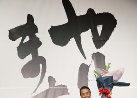 静岡県知事選での勝利を受け、花束を掲げる鈴木康友氏（右）＝２６日夜、静岡市葵区
