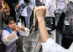 東京都知事選で選挙活動する候補者をスマートフォンで撮影する陣営スタッフ＝２８日、東京都新宿区