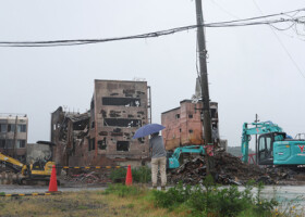 地震で焼失した朝市通り周辺の様子を見詰める人＝６月３０日、石川県輪島市