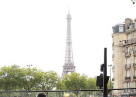 交通規制されたセーヌ川周辺で、柵越しにエッフェル塔を眺める人たち＝２３日、パリ