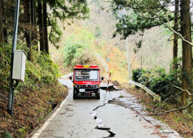 ひび割れがある道路を走って、能登半島地震の被災現場に向かう消防の小型救助車（総務省消防庁提供）