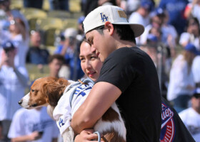 ドジャースタジアムでのセレモニーを終え、愛犬のデコピンを抱え会場を後にするドジャースの大谷（手前）と妻の真美子さん＝１日、ロサンゼルス