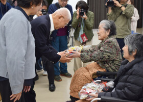 長崎原爆被災者協議会の関係者（左から２人目）に折り鶴を渡す被爆者ら＝２７日、長崎市