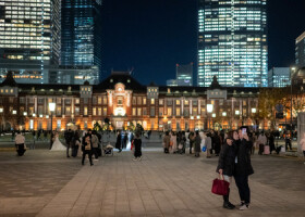 東京駅をバックに写真を撮る人たち＝１６日、東京都千代田区（ＡＦＰ時事）