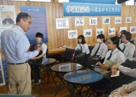 東日本大震災で被災し再建された「ゆりあげ港朝市」の桜井広行代表理事（左端）から話を聞く輪島高校の生徒＝９月２８日、宮城県名取市