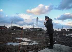 大規模火災で焼けた建物の解体が進む石川県輪島市の観光名所「朝市通り」近くに住む二俣大輔さん（４８）。犠牲者に手を合わせると、「子どもの頃によく遊んだ思い出の場所。地震が先月だったみたいに、あっという間に過ぎた１年だった」と振り返った＝３１日午後