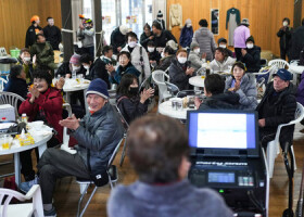 珠洲市役所前の「飯田わくわく広場」で行われたカラオケ大会で、盛り上がる地元の人たち＝３１日午後、石川県