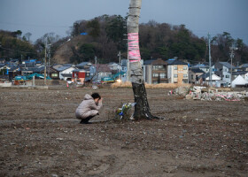 観光名所「朝市通り」付近で手を合わせる人＝１日午後、石川県輪島市