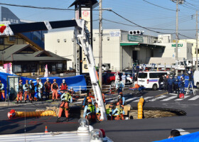 県道交差点の陥没現場で、転落したトラック運転手の救出作業に当たる消防隊員ら＝２８日午後、埼玉県八潮市