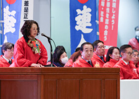 連合の中央集会であいさつする芳野友子会長（壇上）。前列右から２人目は立憲民主党の野田佳彦代表。右端は国民民主党の古川元久代表代行＝２７日午後、東京都千代田区
