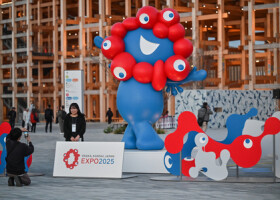 大阪・関西万博公式キャラクター「ミャクミャク」の前で写真を撮る人＝９日、大阪市此花区（ＡＦＰ時事）