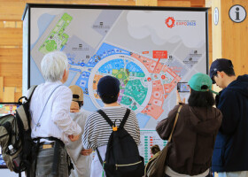 大阪・関西万博会場に設置された地図を見る人たち＝１８日、大阪市此花区