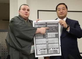 大相撲春場所の番付表を手にする安青錦（左）。右は師匠の安治川親方＝２月２５日、大阪府松原市